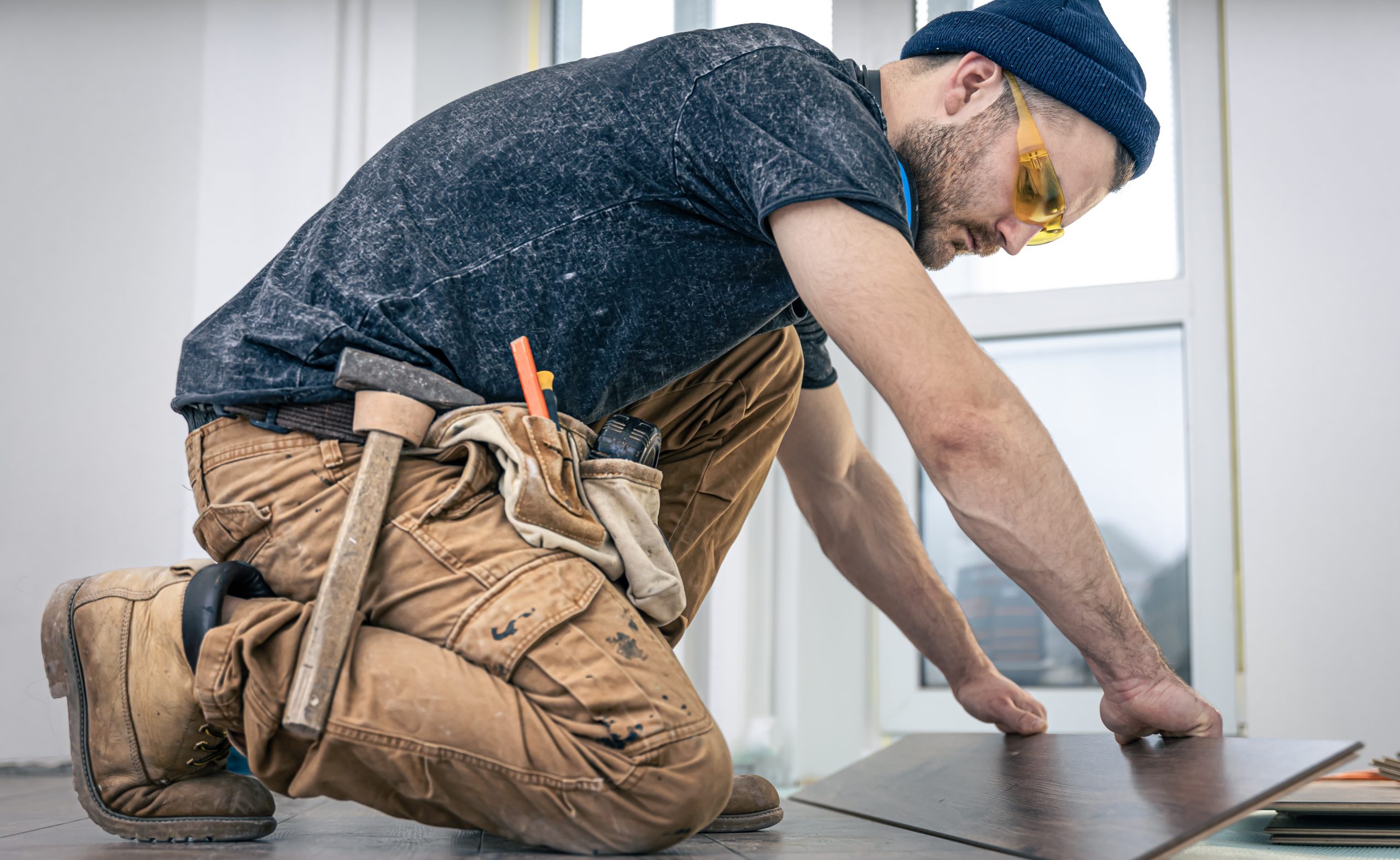 Building contractor worker using hand held worm drive circular saw to cut boards on a new home constructiion project.